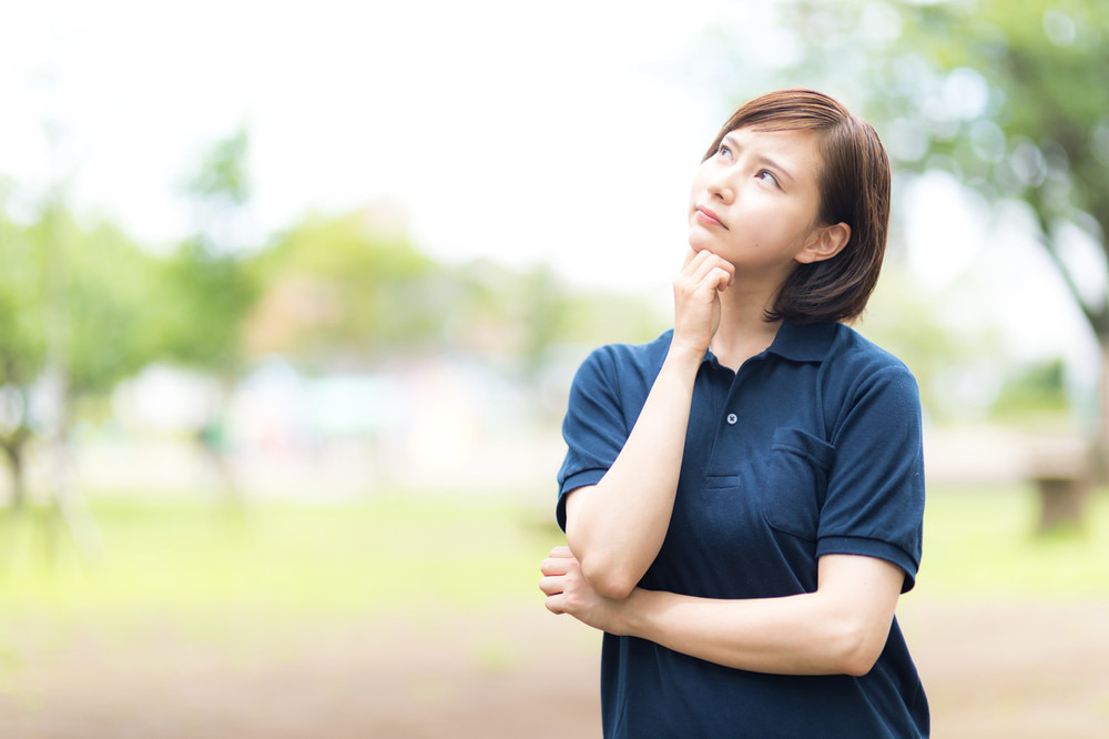 斜め上を向いて考えている女性